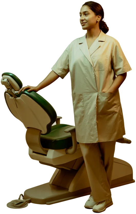 An orthodontist in a cream clinic coat resting a hand on a green dental chair