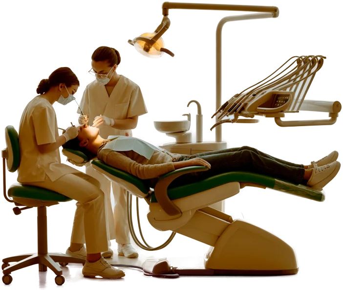 A dentist and an assistant treating a relaxed patient in a green dental chair