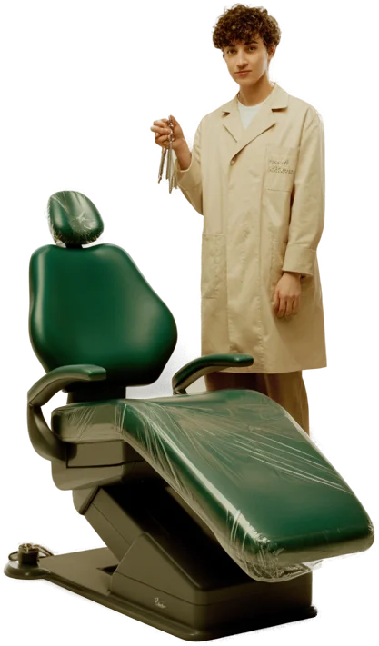 A young dentist with keys in hand beside a brand new dental chair still in its wrap